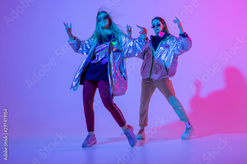 Young stylish girls dancing in the Studio on a colored neon background. Music dj poster design.
