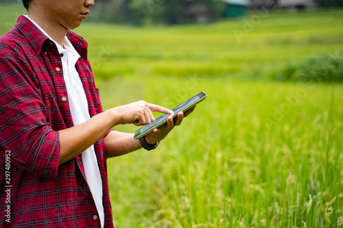 Asian man Agricultural Engineer Test Plants Health and Analyze Data with Tablet laptop in Industrial Greenhouse.Farmer Plantation checking quality by digital agriculture modern technology Concept.