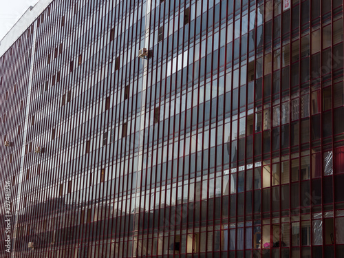 Dark glass wall of a huge residential building. The theme of an emerging housing market under construction