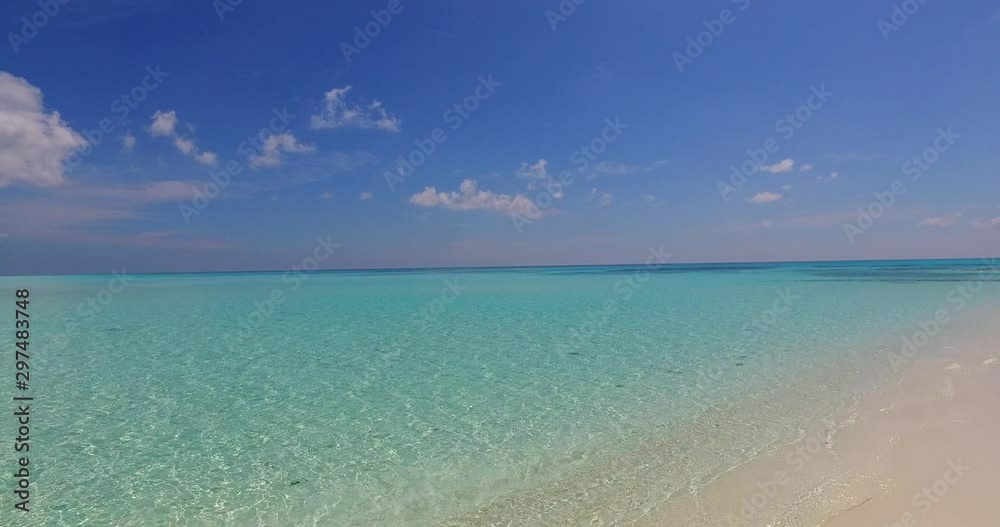 Tropical beach with white sand in Bali, Indonesia, with waves gently breaking on the shore Tropical beach with white sand in Bali, Indonesia, with waves gently breaking on the shore