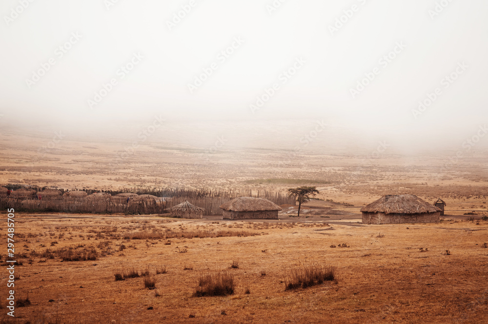 Masai or Maasai Village in empty golden grass plain. Ngorongoro Consevation, Serengeti Savanna forest in Tanzania. - obrazy, fototapety, plakaty 
