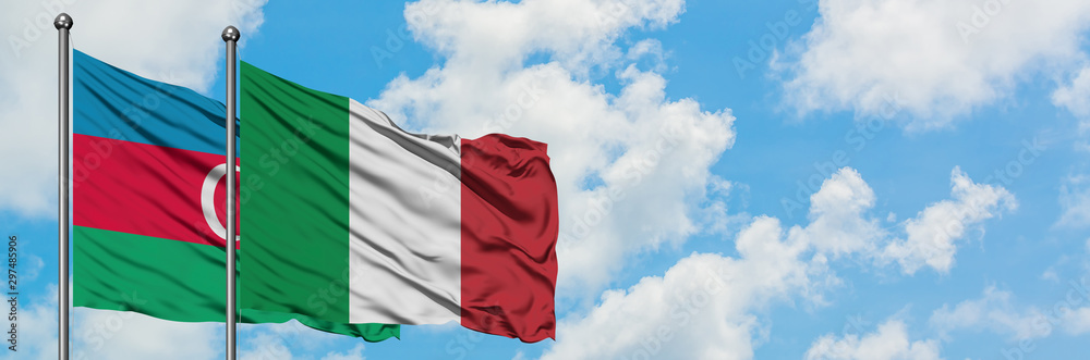 Azerbaijan and Italy flag waving in the wind against white cloudy blue sky together. Diplomacy concept, international relations. Azerbaijan and Italy flag waving in the wind against white cloudy blue sky together. Diplomacy concept, international relations.