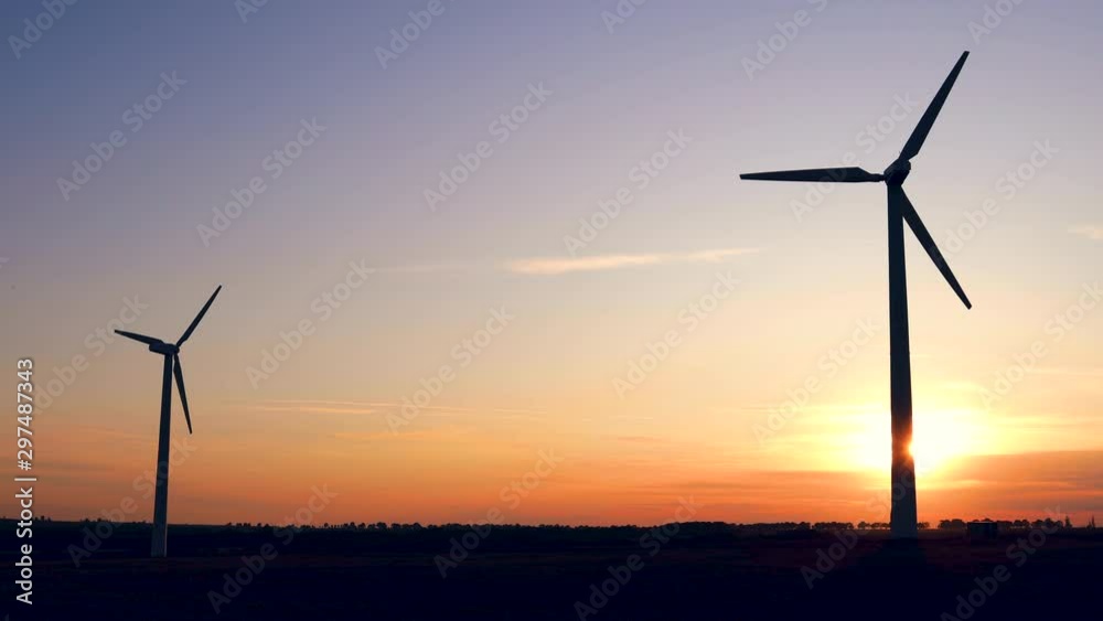 Sunset above the windmills silhouette on the field Sunset above the windmills silhouette on the field