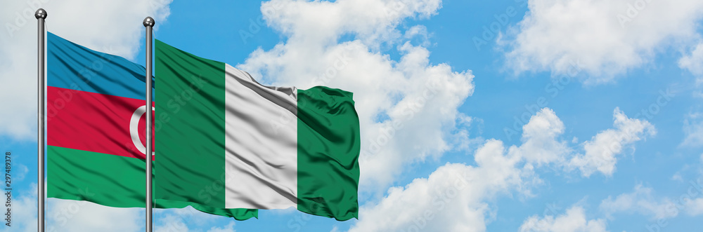 Azerbaijan and Nigeria flag waving in the wind against white cloudy blue sky together. Diplomacy concept, international relations. Azerbaijan and Nigeria flag waving in the wind against white cloudy blue sky together. Diplomacy concept, international relations.