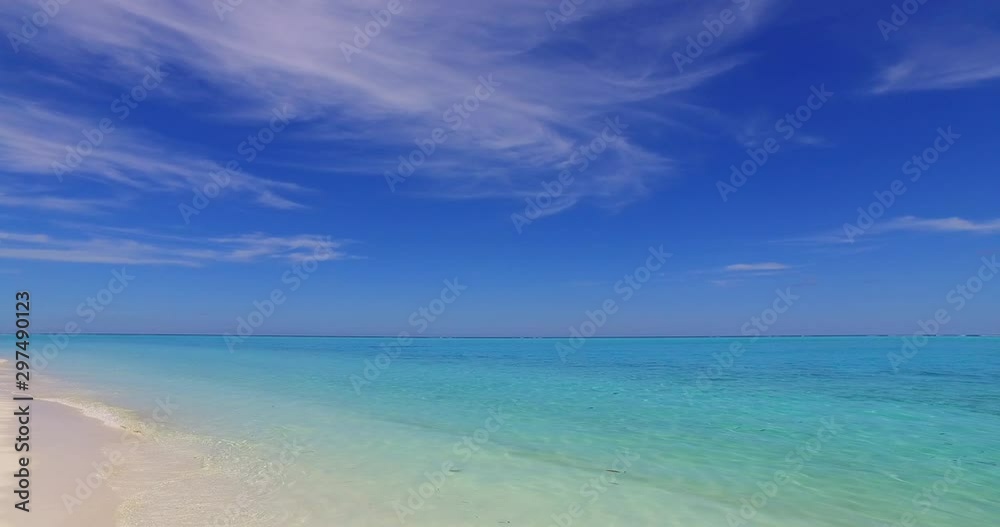 Tropical beach with white sand in Bali, Indonesia, with waves gently breaking on the shore Tropical beach with white sand in Bali, Indonesia, with waves gently breaking on the shore