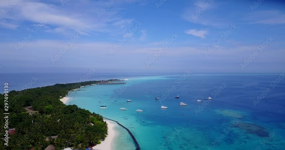 Flying perspective of tropical island in the Maldives where the ocean melts with the sky at the horizon