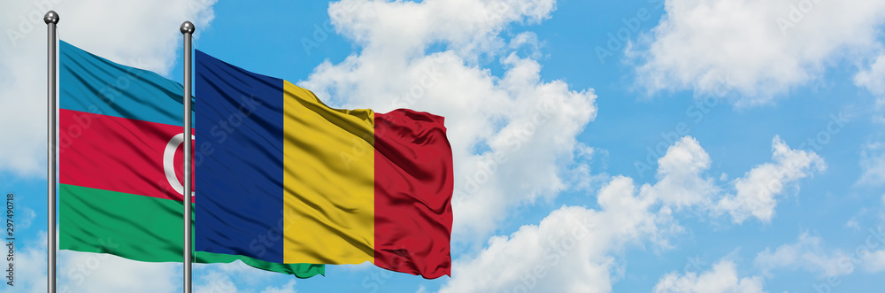 Obraz premium Azerbaijan and Romania flag waving in the wind against white cloudy blue sky together. Diplomacy concept, international relations.