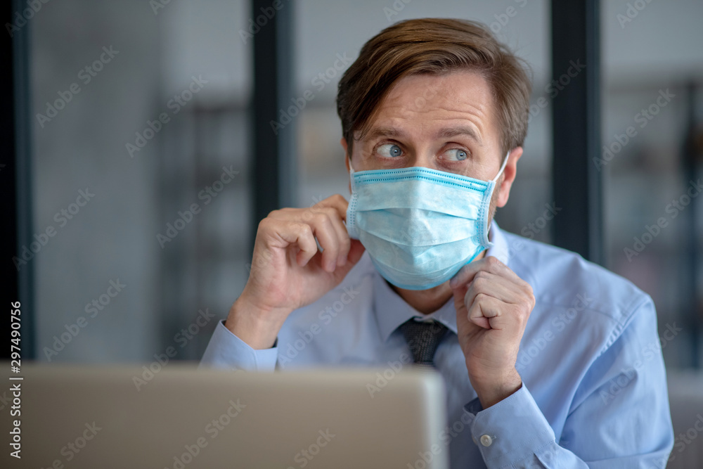 Office worker using protective mask not to infect his colleagues Office worker using protective mask not to infect his colleagues