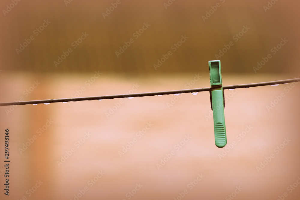 Plastic clothespine on wet wire after rain in the backyard close-up Plastic clothespine on wet wire after rain in the backyard close-up