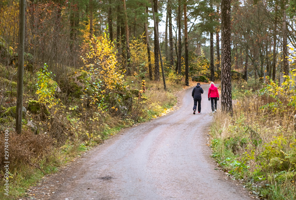 Two people are walking in the autumn park, sporting lifestyle and health. Two people are walking in the autumn park, sporting lifestyle and health.