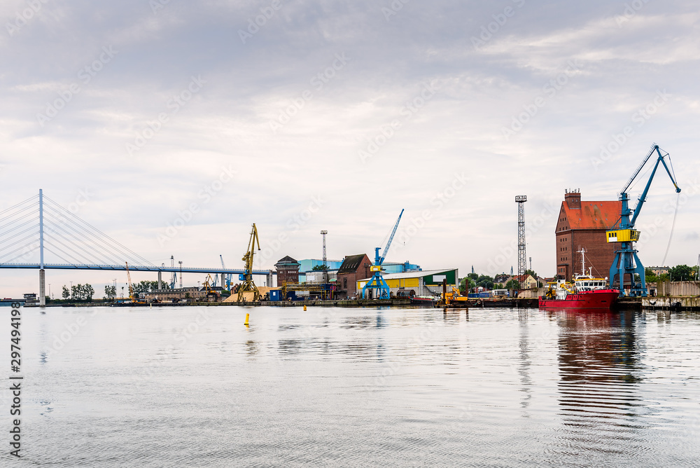 Panoramic view of the commercial harbour of Stralsund with cranes and tugboat.