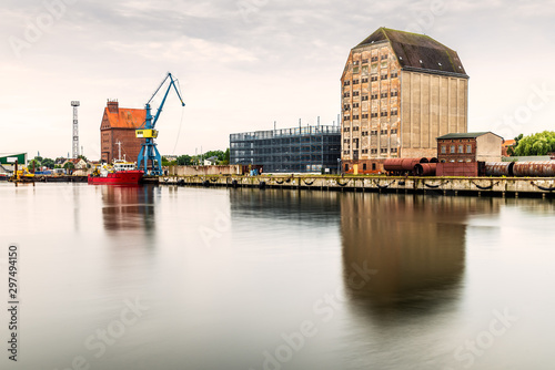 Panoramic view of the commercial harbour of Stralsund with cranes, warehouses and tugboat.