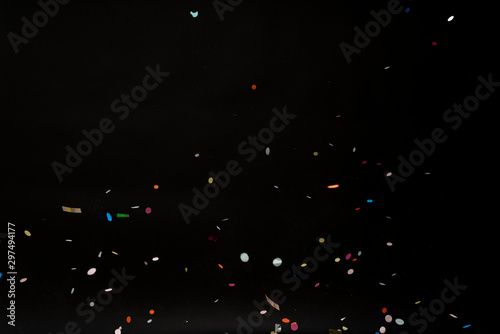 colorful party confetti flying in front of black