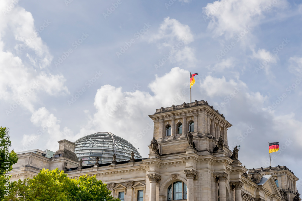Φωτογραφία German flags waving on the Reichstag building in the historic center of Berlin,