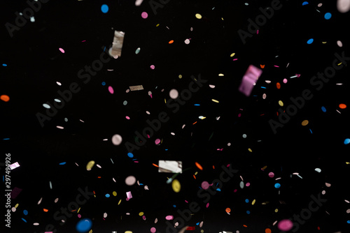 colorful party confetti flying in front of black