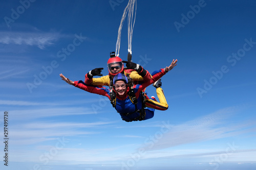 Tandem skydiving. An instructor and his woman-passenger are flying in the sky. photo