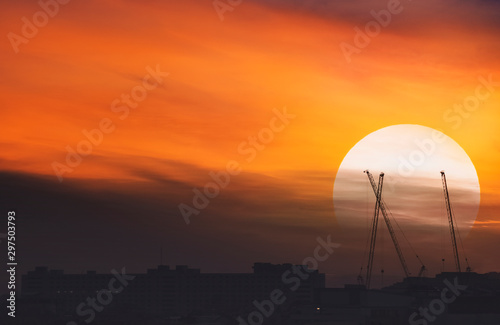 Sunrise and silhouette images of cranes and buildings  in the city.