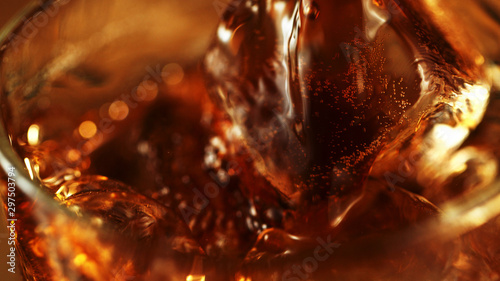 Super macro shot of pouring cola drink into glass