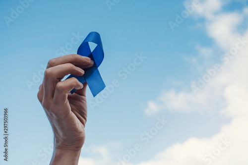 Εκτύπωση καμβά Man Hands holding blue ribbon over blue sky, Prostate Cancer Awareness, November