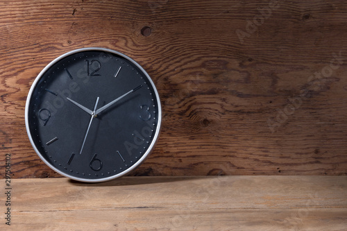 black clock on brown wood background