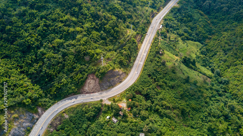 Picture aerial view of curve road from above, road with cars through green forest and mountain landscape of rural Thailand at northern region