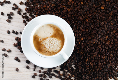 Cup of coffee and coffee beans on the table. Fresh espresso. Flat lay.