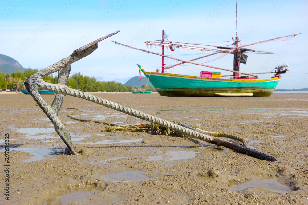 Obraz premium closeup anchor with fishing boat on the coast