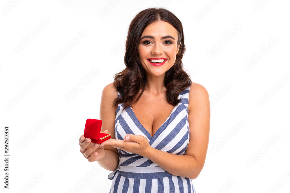 A young girl with a delightful smile, flat teeth, red lipstick, long wavy chestnut hair, beautiful makeup, in a white and blue dress in a stripe with a cleavage holds a red ring box in her hands A young girl with a delightful smile, flat teeth, red lipstick, long wavy chestnut hair, beautiful makeup, in a white and blue dress in a stripe with a cleavage holds a red ring box in her hands