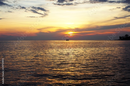 Sunset over sea with reflection in water  majestic clouds in the sky.