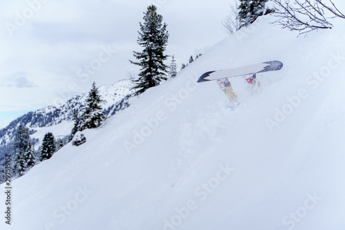 Photo of sporting man riding snowboard , legs sticking up