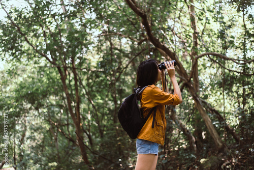 Traveller young asian women using binoculars in forest,Enjoying with bird watching © gballgiggs