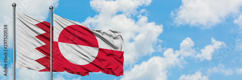 Bahrain and Greenland flag waving in the wind against white cloudy blue sky together. Diplomacy concept, international relations.