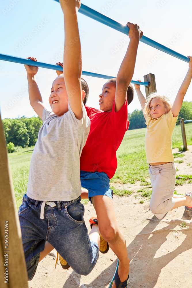 Drei Jungen hangeln an einem Klettergerüst