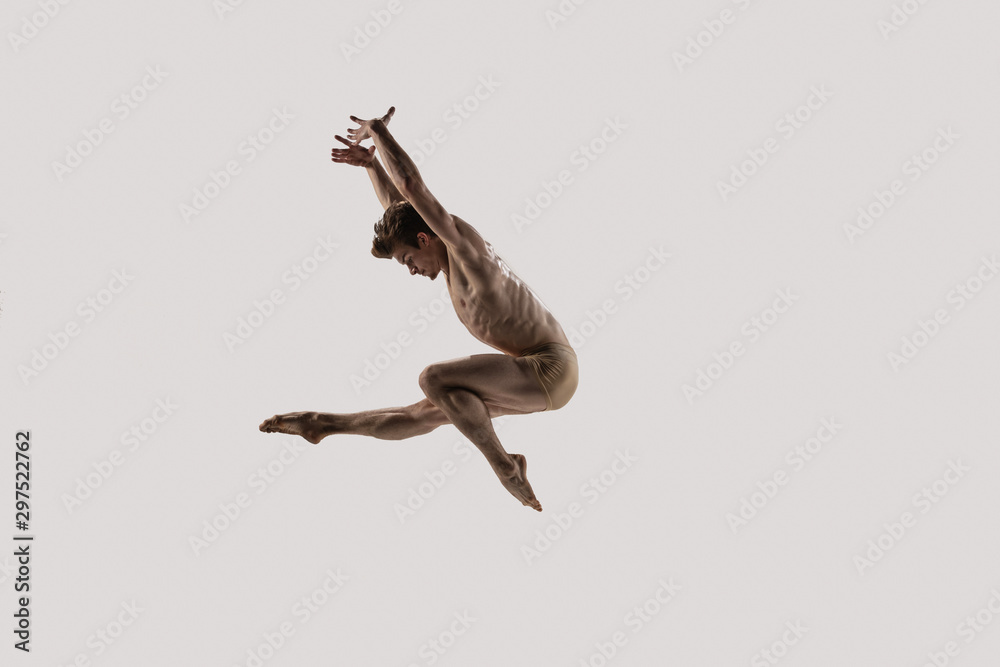 Fototapeta Modern ballet dancer. Contemporary art ballet. Young flexible athletic man.. Studio shot isolated on white background. Negative space.