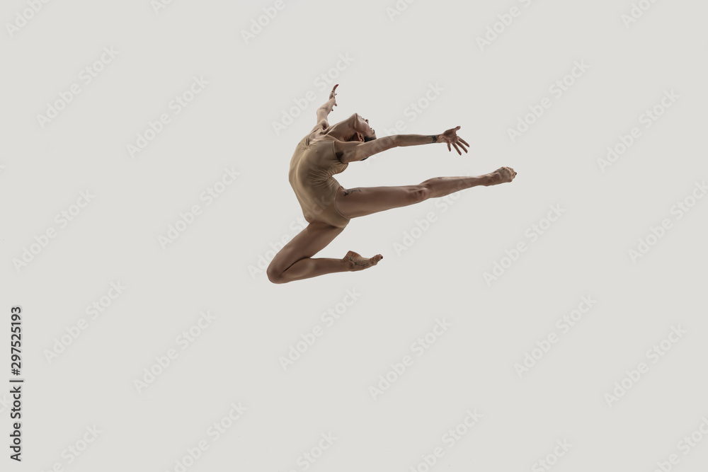 Fototapeta Modern ballet dancer. Contemporary art ballet. Young flexible athletic woman.. Studio shot isolated on white background. Negative space.