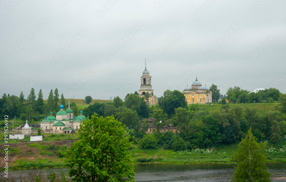 A dilapidated monastery on the river Bank against a dark cloudy sky. A dilapidated monastery on the river Bank against a dark cloudy sky.