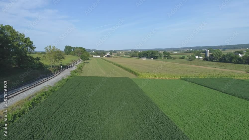 Aerial View Close up of Green Agricultural Farm Lands Next to a Rail Road Track in Amish Countryside on a Sunny Summer Day Aerial View Close up of Green Agricultural Farm Lands Next to a Rail Road Track in Amish Countryside on a Sunny Summer Day