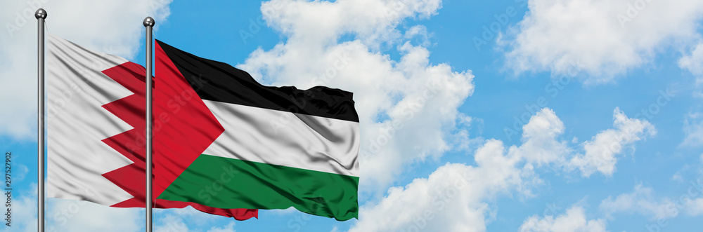 Bahrain and Palestine flag waving in the wind against white cloudy blue sky together. Diplomacy concept, international relations. Bahrain and Palestine flag waving in the wind against white cloudy blue sky together. Diplomacy concept, international relations.