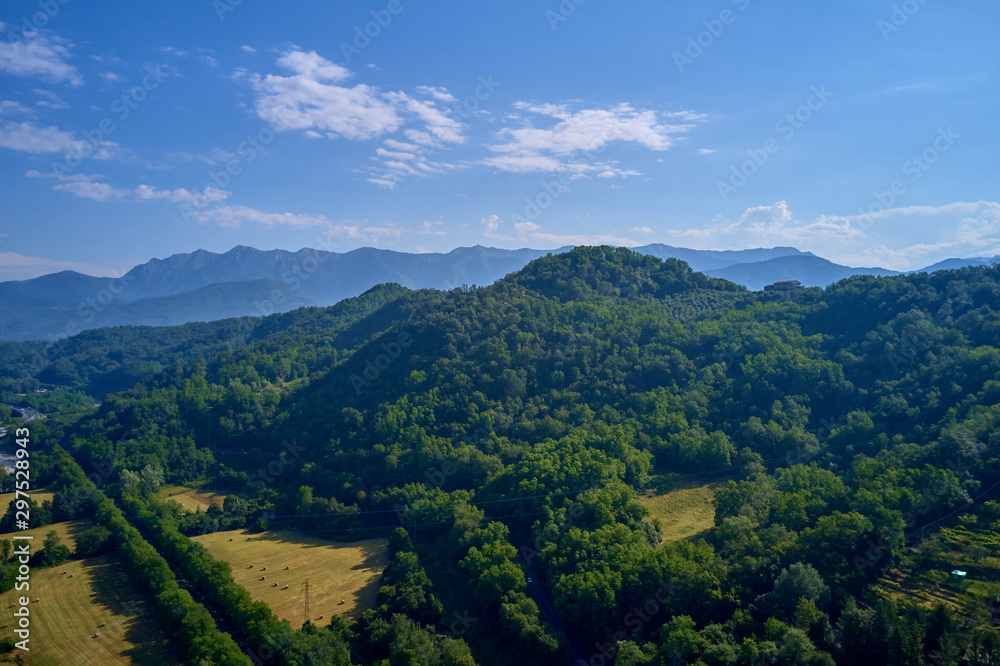 Aerial view of the Alps surrounded by meadows, forests and mountains. Flying on drone.