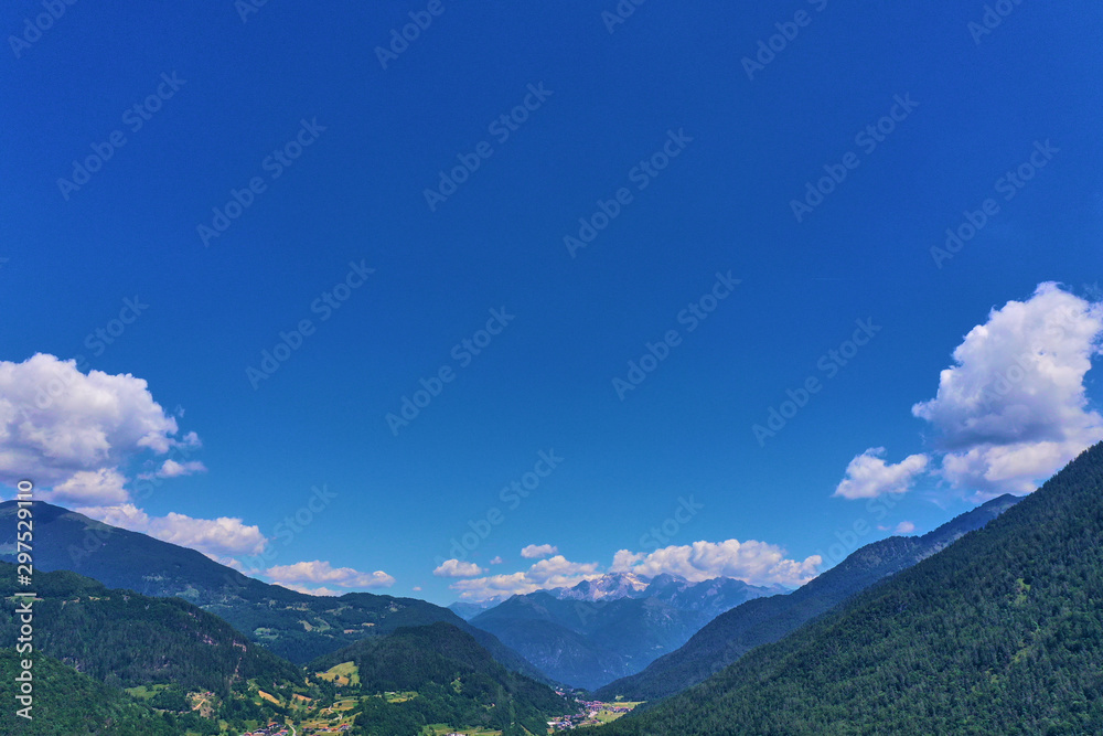 defaultAerial view of the Alps surrounded by meadows, forests and mountains. Flying on drone.