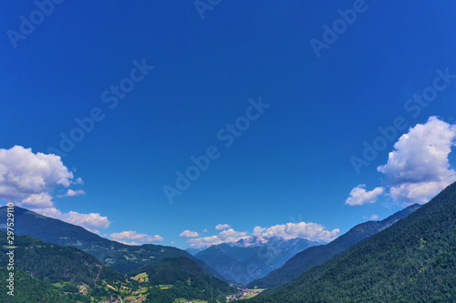 defaultAerial view of the Alps surrounded by meadows, forests and mountains. Flying on drone. © Berg