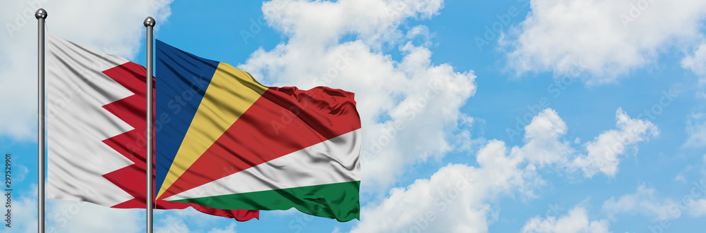 Bahrain and Seychelles flag waving in the wind against white cloudy blue sky together. Diplomacy concept, international relations. Bahrain and Seychelles flag waving in the wind against white cloudy blue sky together. Diplomacy concept, international relations.