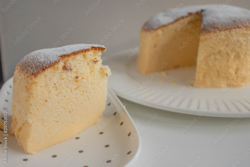 Japanese jiggly cheesecake topped with sugar Powder with slice on plate. Japanese jiggly cheesecake topped with sugar Powder with slice on plate.