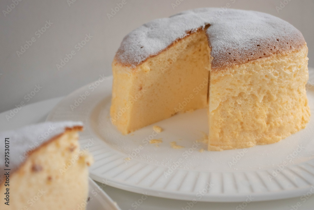 Japanese jiggly cheesecake topped with sugar Powder with slice on plate. Japanese jiggly cheesecake topped with sugar Powder with slice on plate.