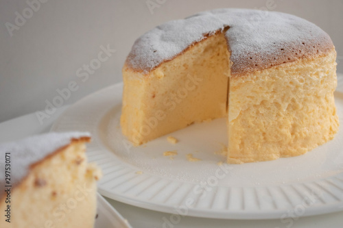 Japanese jiggly cheesecake topped with sugar Powder with slice on plate.
