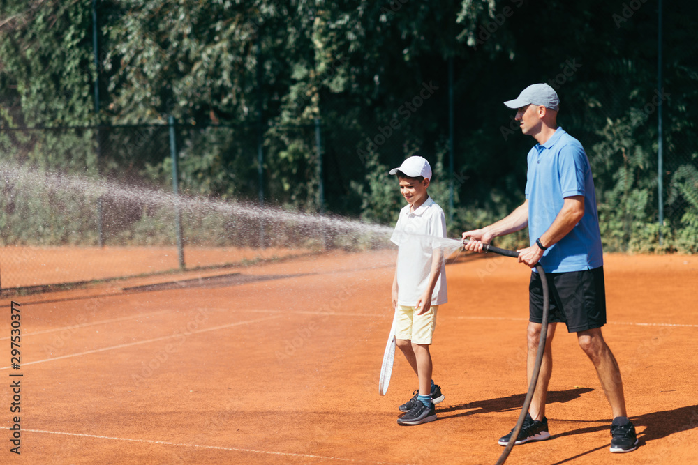 Tennis Coach Spraying a Clay Court with Water