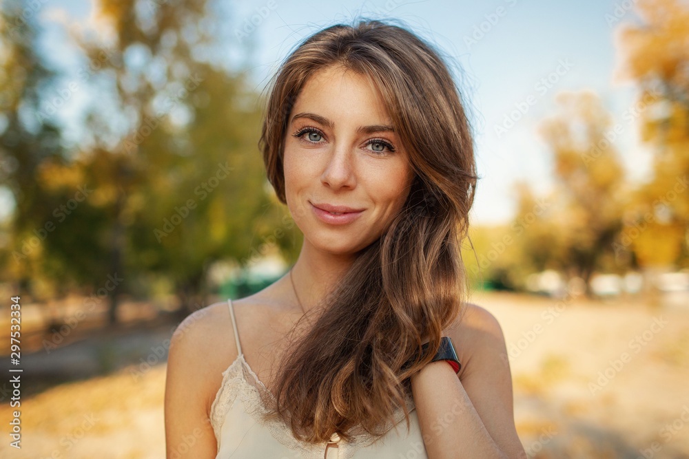 Portrait of a beautiful girl on a background of autumn landscape