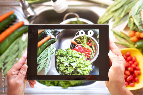 A nice picture with the tablet to show clean vegetables. Healthy food to stay in shape and very welcome to vegan and vegetarian people