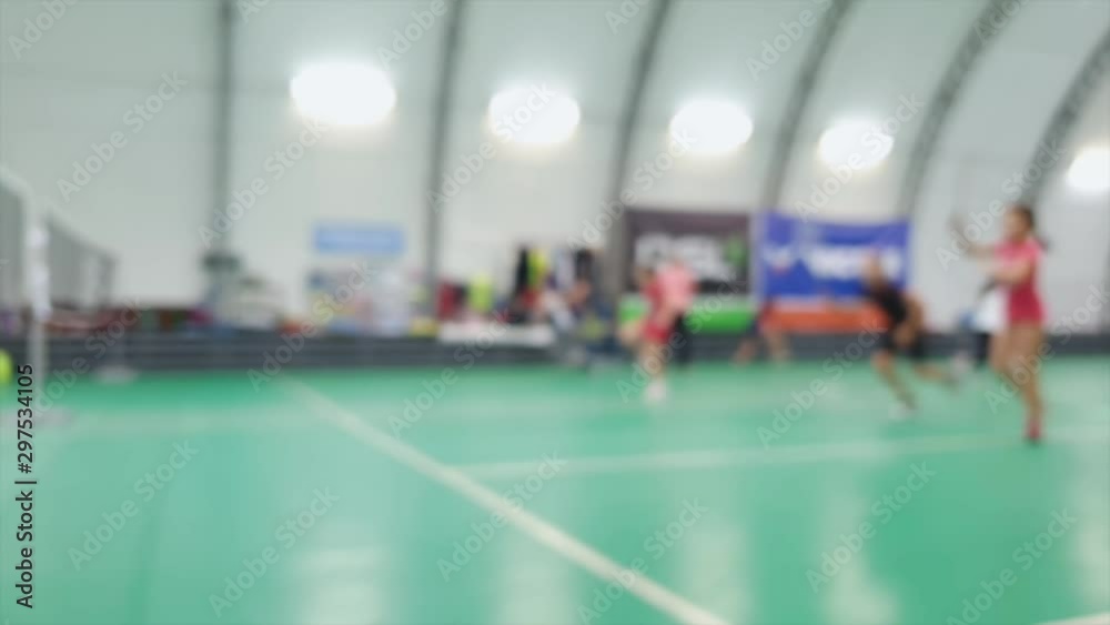 Blurred kids training with rackets on badminton court Blurred kids training with rackets on badminton court
