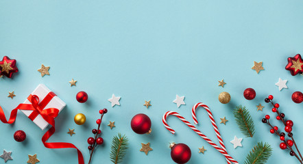 Gift or present box and holiday decorations on blue background top view. Christmas greeting card. Flat lay.